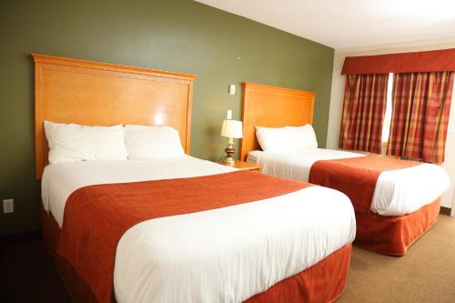 a hotel room with two beds and a window at Chateau Motel in Edmonton