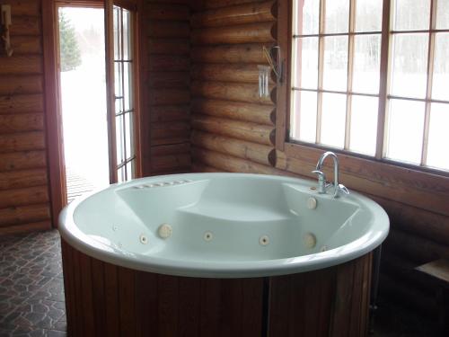 a large bath tub in a room with windows at Jaun-Ieviņas in Rauna