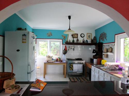 una cucina con frigorifero bianco e tavolo di Casa Gwendoline - Albergue / Hostel / AL - Caminho da Costa a Vila Nova de Cerveira