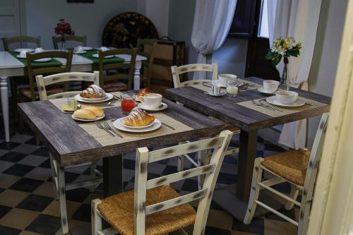 einem Holztisch mit Teller mit Lebensmitteln darauf in der Unterkunft Xenía B&B in Piazza Armerina