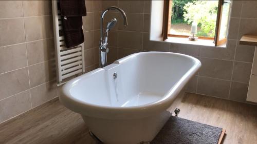 une baignoire dans une salle de bain avec une fenêtre dans l'établissement GiteDordogne, à Jumilhac-le-Grand