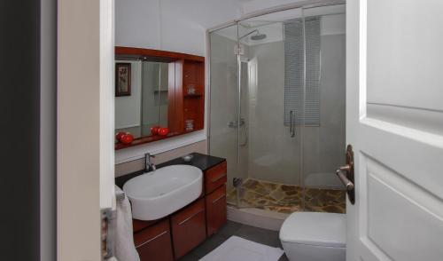 y baño con aseo, lavabo y ducha. en Blue Water Boutique Hotel, en Negombo
