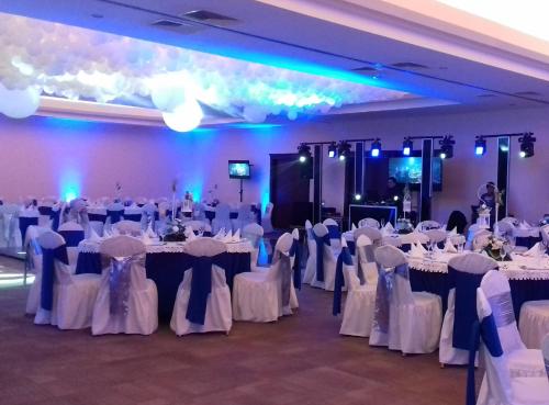 a banquet hall with white tables and white chairs at Hotel Hacienda Real in Ciudad del Carmen