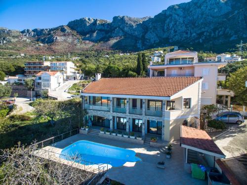 a house with a swimming pool and a mountain at Villa Narcissus Montenegro KO Sveti Stefan in Sveti Stefan