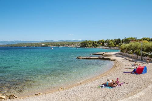 a group of people laying on a beach at Hotel Vila Rova in Malinska
