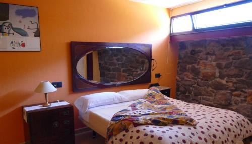 Casa Rural Apartamento El Chaveto في Herreros: غرفة نوم مع سرير ومرآة على الحائط