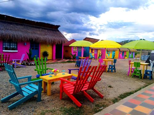 a group of colorful chairs and tables with umbrellas at Dunas Tatacoa in Villavieja