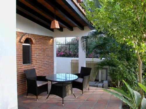 a patio with a glass table and chairs at Aventura Pacifico Boutique Suites & Villas in Bucerías