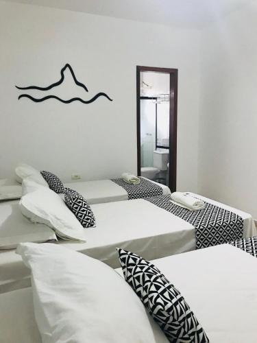 a group of beds in a room with a mirror at Pousada Morro do Pico in Fernando de Noronha