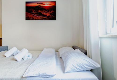 a bed with white sheets and pillows in a room at Apartamenty Novomiejska 17 in Lublin