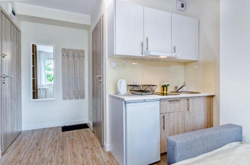 a kitchen with white cabinets and a sink at Apartamenty Novomiejska 17 in Lublin