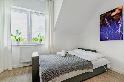 a bedroom with a bed and a painting on the wall at Apartamenty Novomiejska 17 in Lublin