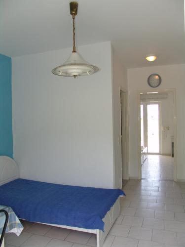 a bedroom with a blue bed and a clock on the wall at Kontessa Apartments in Kefalos