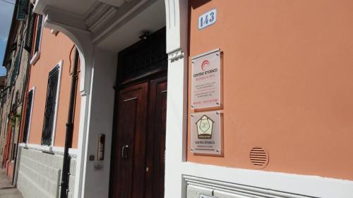 a building with a door and a sign on it at Centro Storico Rooms in Ferrara