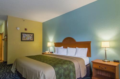 a hotel room with a large bed and two lamps at Econo Lodge Darien in Darien