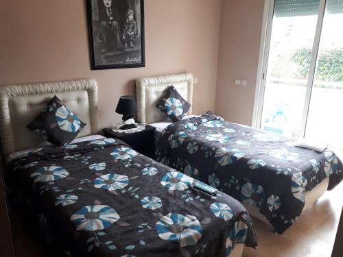two beds sitting next to each other in a bedroom at Résidence Dreamland in Sidi Rahal