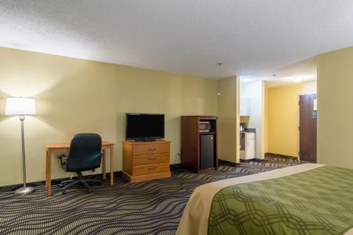 a hotel room with a bed and a desk and a television at Econo Lodge Darien in Darien