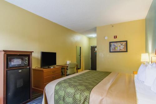 a hotel room with a bed and a tv at Econo Lodge Darien in Darien