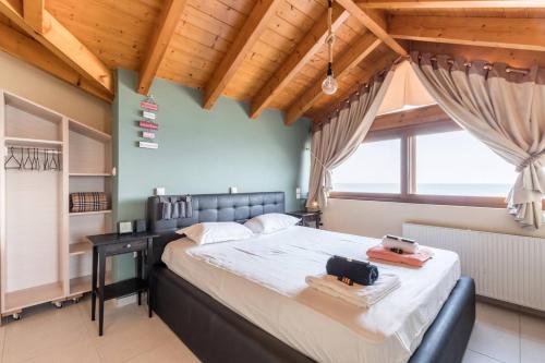 a bedroom with a large bed in a room with wooden ceilings at Savva's Surf House in Artemida
