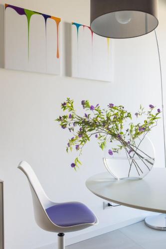 a white chair and a table with a vase of flowers at Agriturismo l'Adagio in Badalucco