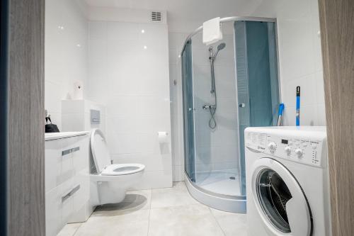 uma casa de banho com um WC e uma máquina de lavar roupa em FUDA APARTAMENT BRUKSELSKA 11 em Gorzów Wielkopolski