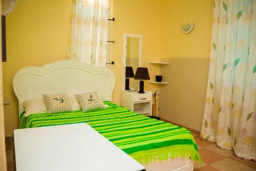 a bedroom with a bed with a green and white blanket at Cosi Dolce in Pereybere