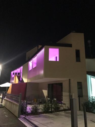 a building with purple lights on it at night at Villa Alcova in Caorle