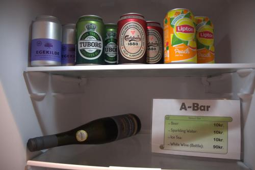 a bottle of beer and a sign in a refrigerator at A-Bed in Esbjerg