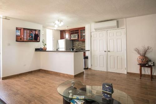 オーチョ・リオスにあるEmerald One Bedroom Suite At Turtle Towersのリビングルーム(ガラスのテーブル付)、キッチン