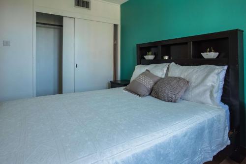 a bedroom with a large white bed with two pillows at Emerald One Bedroom Suite At Turtle Towers in Ocho Rios