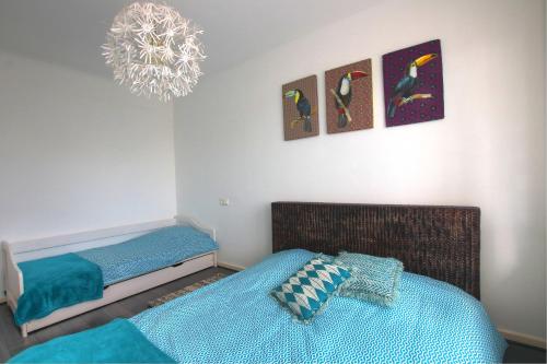 1 dormitorio con 2 camas individuales y lámpara de araña en Au Berceau des Cigognes en Sélestat