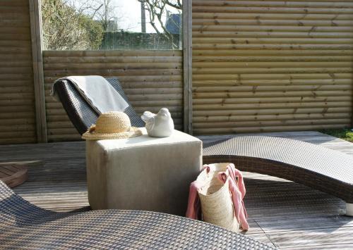 a patio with a chair and a hat and shoes at Gîtes Le Bout du Monde in Le Conquet