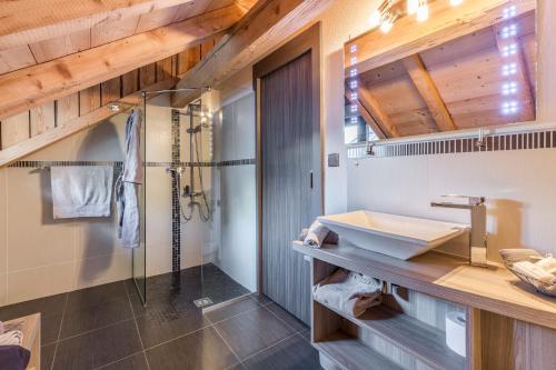 La salle de bains est pourvue d'un lavabo et d'une douche. dans l'établissement Les Edelweiss Mont-Blanc - Gîte Classé 3 Etoiles, à Passy