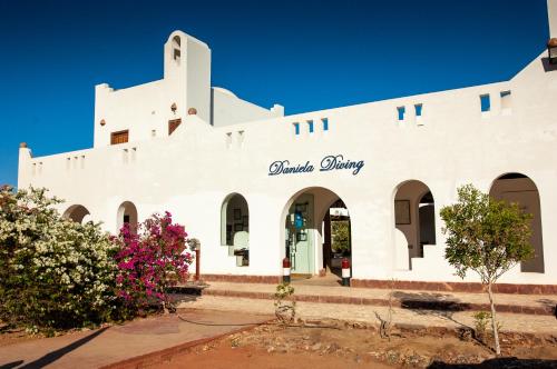 a white building with the words miracle clinic on it at Daniela Diving Resort Dahab in Dahab