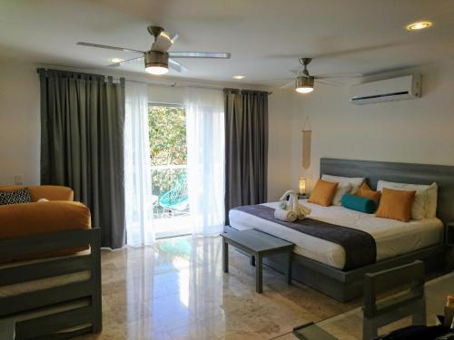 Un dormitorio con una cama grande y una ventana en 5th Coral Suite, en Playa del Carmen