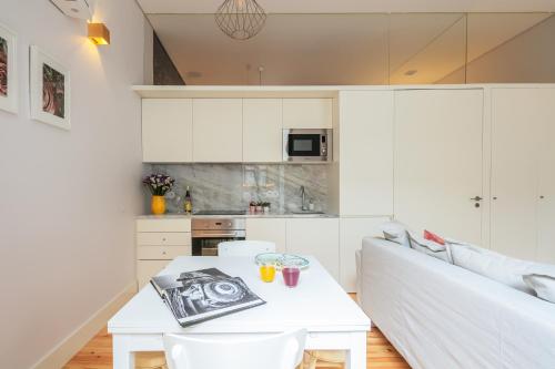 a living room with a white table and a white couch at Indulge Porto Flats in Porto