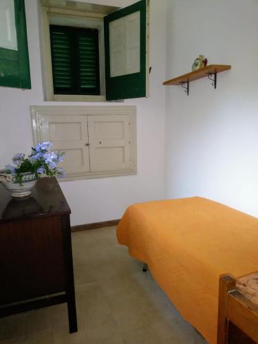 a bedroom with a bed and a table with flowers on it at Nunziata in Mineo