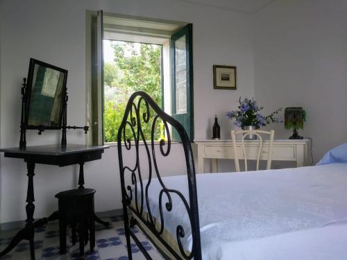 a bedroom with a bed and a desk and a window at Nunziata in Mineo
