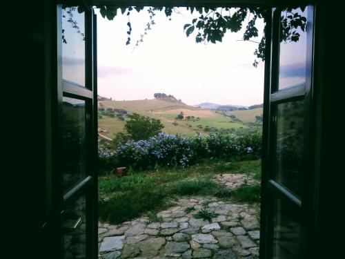 an open door looking out at a field of flowers at Nunziata in Mineo