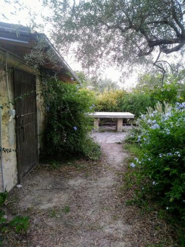 a park bench sitting next to a building with flowers at Nunziata in Mineo