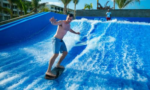 a man riding a wave on a surfboard in a water park at Royalton Bavaro, An Autograph Collection All-Inclusive Resort & Casino in Punta Cana