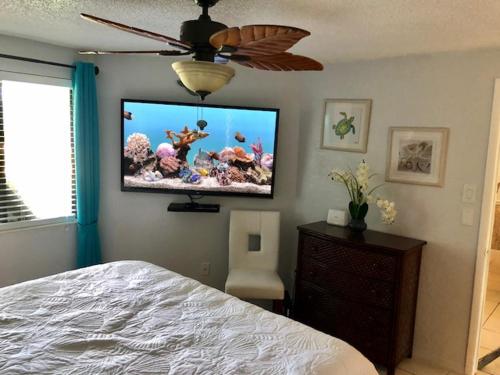 a bedroom with a bed and a flat screen tv on the wall at 2 Bedroom , 2 Bath , Villa in Oldsmar