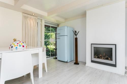 a living room with a refrigerator and a fireplace at Julia's Holiday Home in Simpelveld