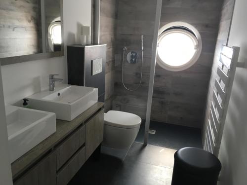 a bathroom with a sink and a toilet and a window at L'Île de Lumière in Rivedoux-Plage