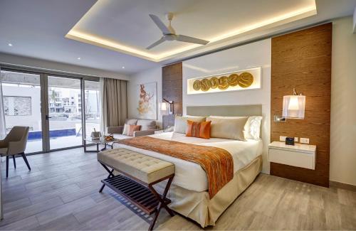 a hotel room with a bed and a living room at Royalton Bavaro, An Autograph Collection All-Inclusive Resort & Casino in Punta Cana