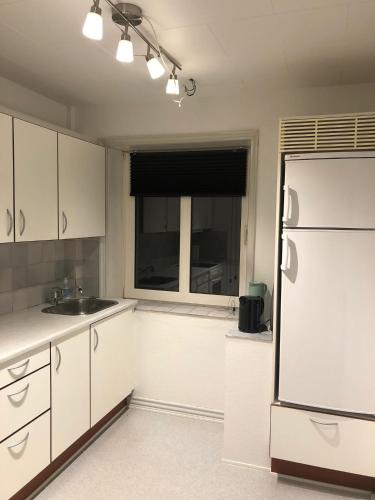 a kitchen with a white refrigerator and a window at Hel lejlighed Thisted Midtby in Thisted
