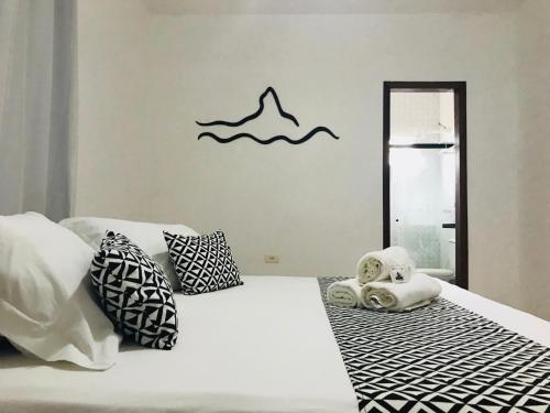 a bedroom with a bed with pillows and a mirror at Pousada Morro do Pico in Fernando de Noronha