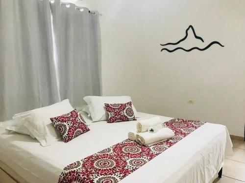 a bedroom with two beds with red and white pillows at Pousada Morro do Pico in Fernando de Noronha