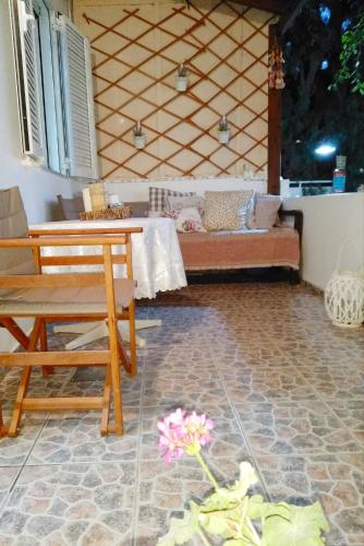 a patio with a table and a couch in a room at Polymnia's apartment in Matala