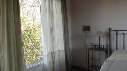 1 dormitorio con cama y ventana grande en Departamentos R y R Italia en Tandil